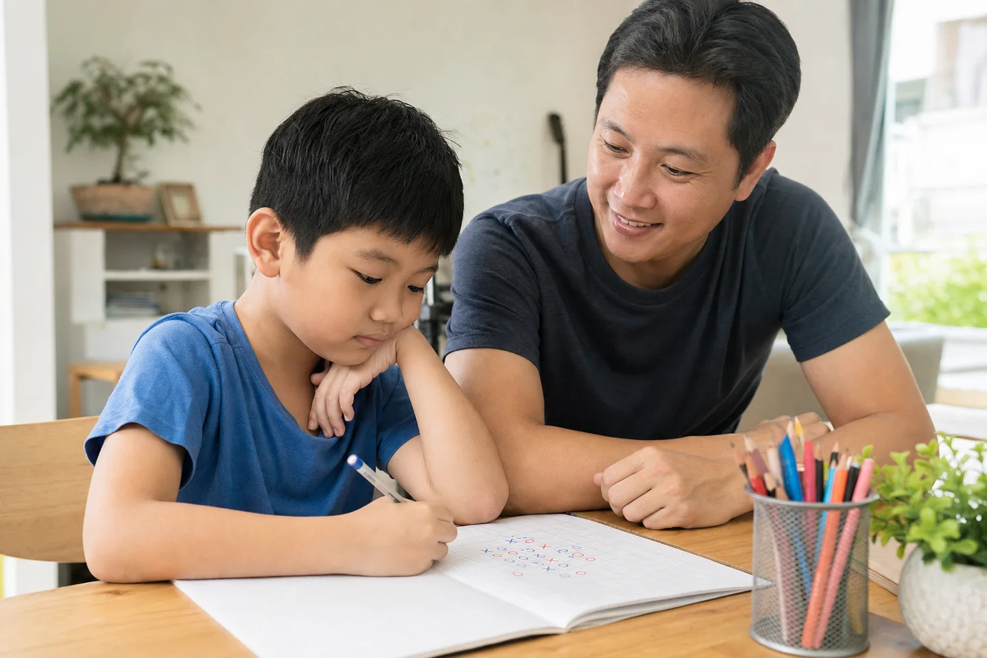 Người cha cùng con trai chơi cờ caro trên giấy ô ly tại bàn học gia đình